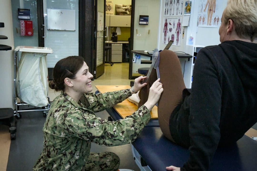 A physical therapist measures a patient's leg.. Cover image for: AI Medical Scribe for Pain Management Clinics.