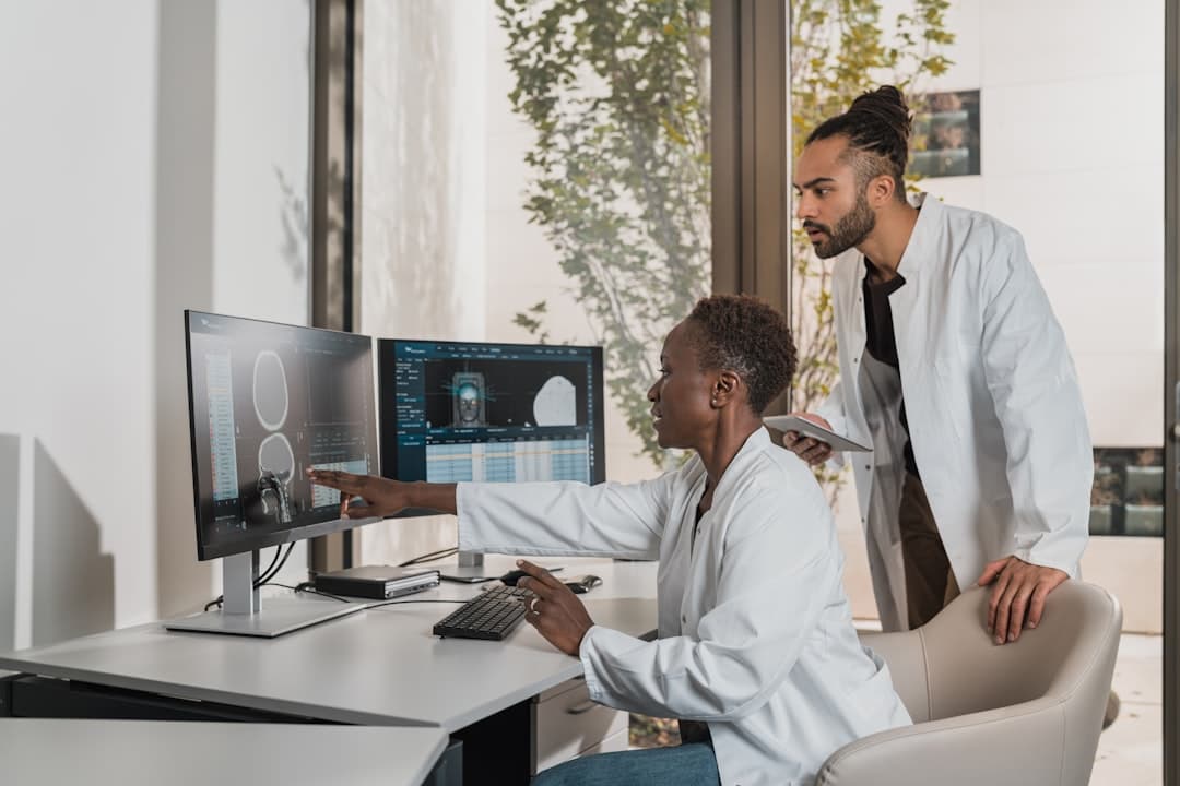 a man showing something on the computer. Cover image for: AI Medical Scribe for Locum Tenens and Traveling Physicians.