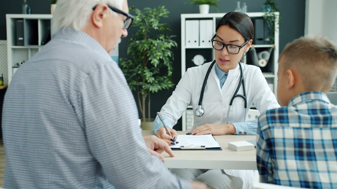 Doctor consulting with elderly man and child.. Cover image for: AI Medical Scribe for Primary Care: Documentation Guide.