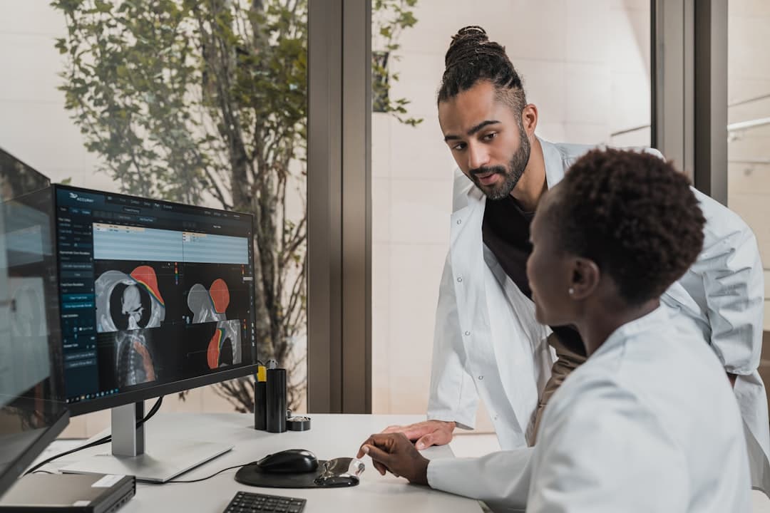 a few men looking at a computer screen. Cover image for: Structured vs Unstructured Clinical Documentation: Which Is Better.