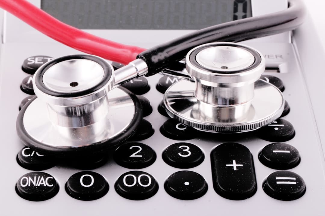a stethoscope sitting on top of a calculator. Cover image for: Calculating the True Cost of Physician Documentation Time.