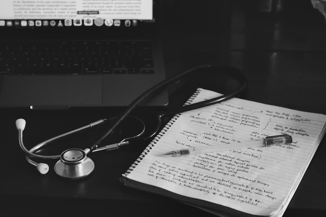 a notebook with a stethoscope on top of it next to a laptop. Cover image for: What Is an AI Medical Scribe? A Complete Guide for Healthcare Providers.