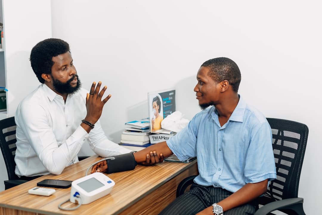 Two men sitting at a desk talking to each other